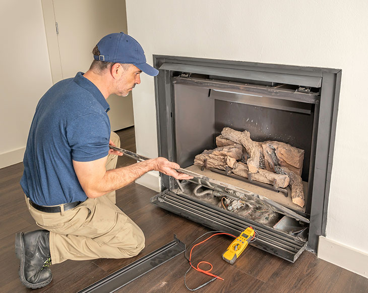 technician repairing a gas fireplace